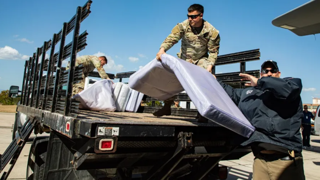Fotografía del 14 de febrero cedida por el Ejército de los Estados Unidos donde aparecen miembros del servicio militar estadounidense transportando elementos para los inmigrantes indocumentados como parte de la Operación Guardia Sur en la Estación Naval de la Bahía de Guantánamo (Cuba).