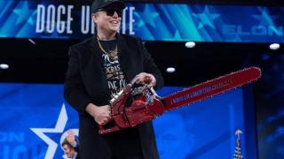 Elon Musk, CEO de Tesla y SpaceX, sostiene una motosierra durante un discurso.