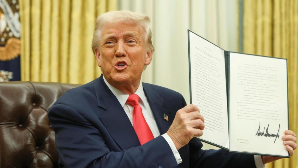 El presidente de Estados Unidos, Donald Trump , sostiene una orden ejecutiva en el Despacho Oval, en la Casa Blanca.