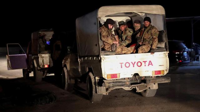 Fuerzas sirias viajan en vehículos militares mientras se dirigen a Latakia.