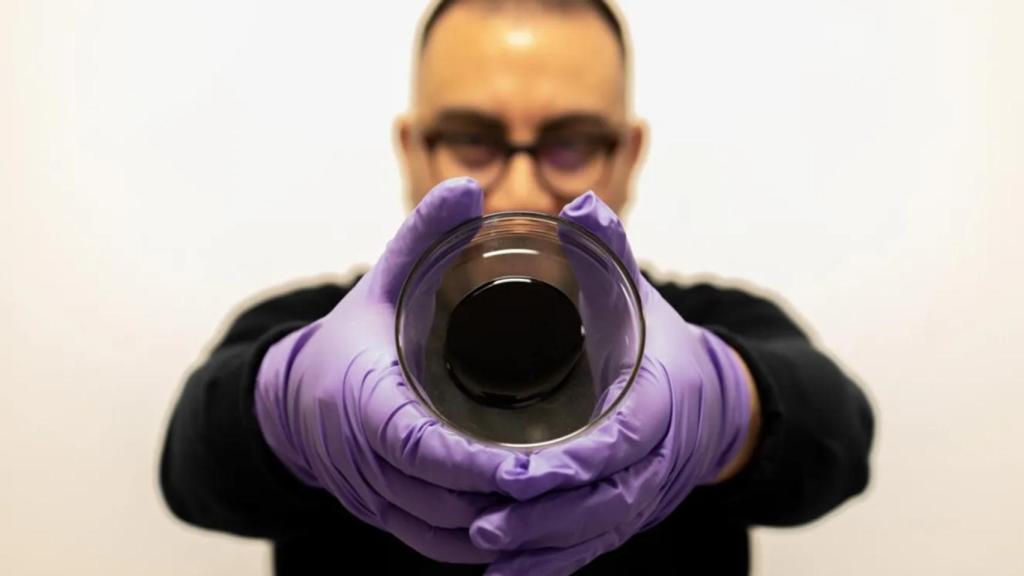 El doctor Norambuena-Contreras de la Universidad de Swansea sujetando una muestra del asfalto autorreparador.