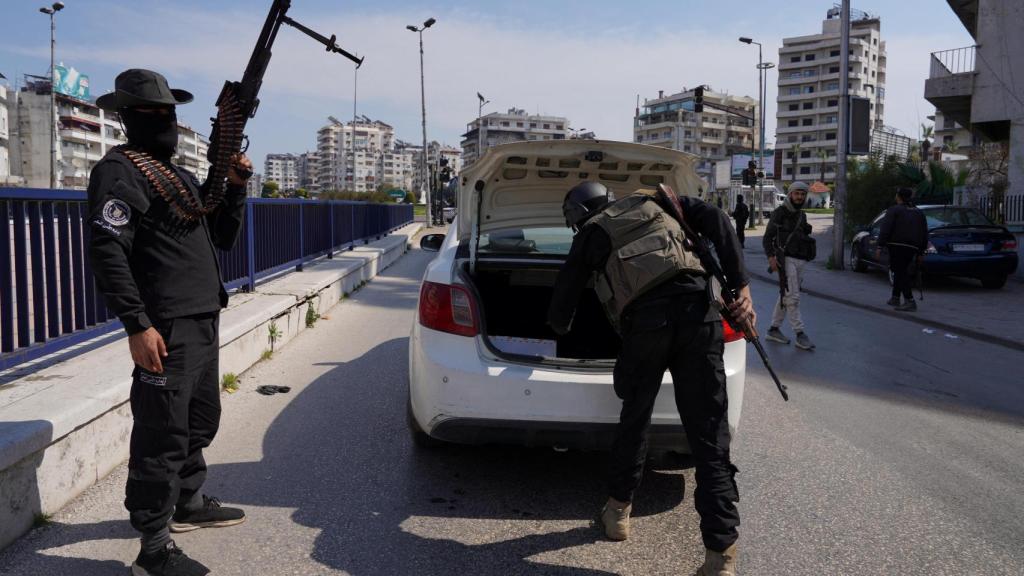 Las fuerzas de seguridad sirias revisan un coche en Latakia.