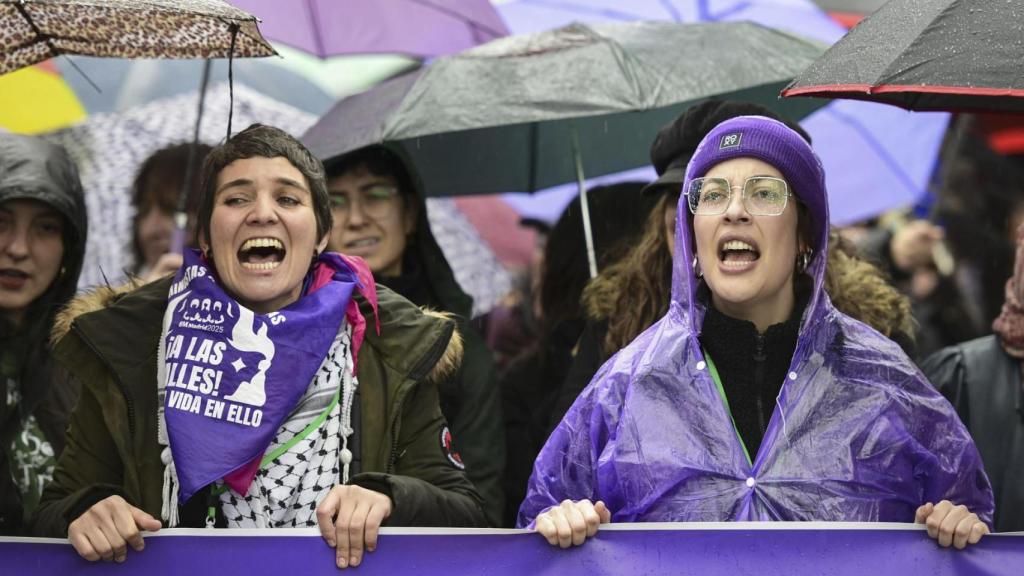 Dos jóvenes en la cabecera de la manifestación de la Comisión 8M en Madrid.
