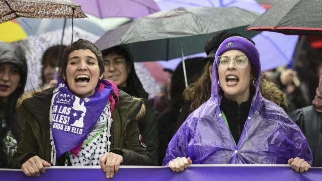 Dos jóvenes en la cabecera de la manifestación de la Comisión 8M en Madrid.