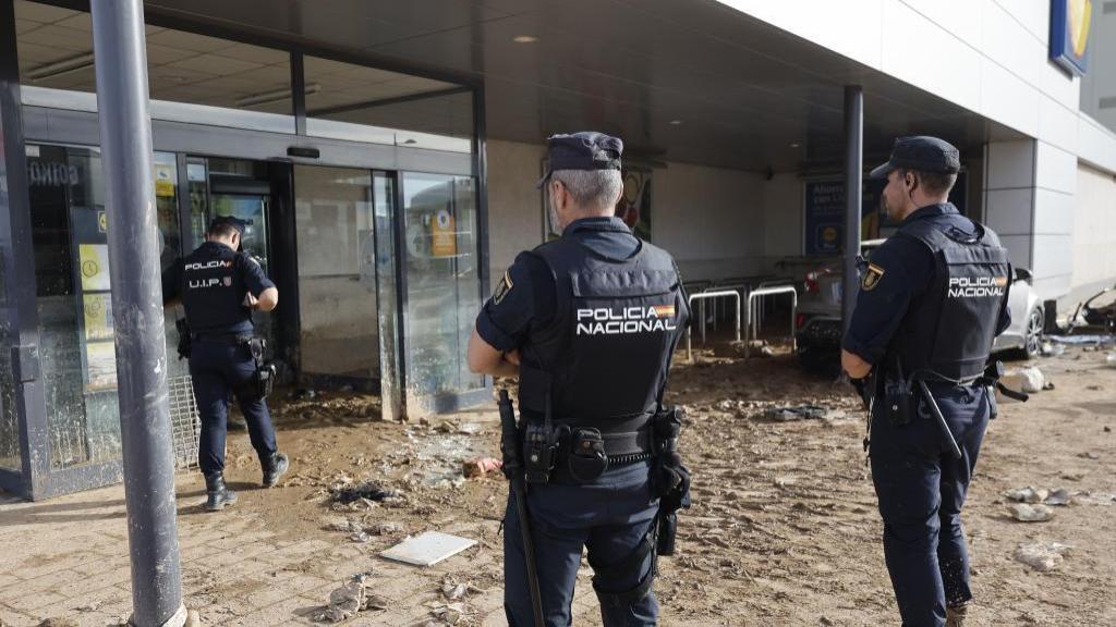 Agentes de la Policía Nacional junto a un supermercado de Alfafar tras la dana. Efe