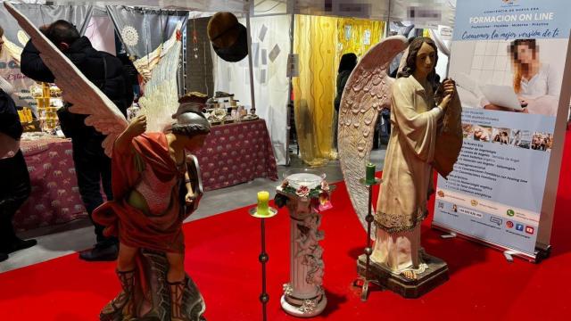 Dos ángeles presentes en la feria esotérico de Madrid, con un recipiente de agua bendita.