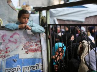 Un grupo de palestinos se reúne en Jan Yunis, al sur de la Franja, para recibir comida.