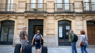 Imagen de archivo. Turistas y vecinos entrando a un edificio.