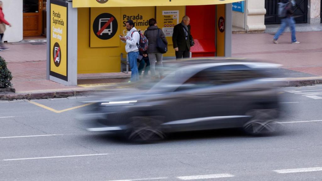 Varias personas aguardan en una parada de autobús suprimida por las Fallas. EFE/Kai Försterling