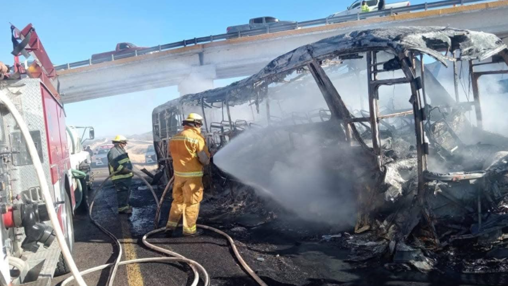 Los bomberos apagan el fuego del autobús accidentado en Durango (México).