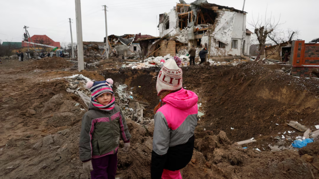 Niños junto a escombros en Kiev, Ucrania, tras un ataque ruso.