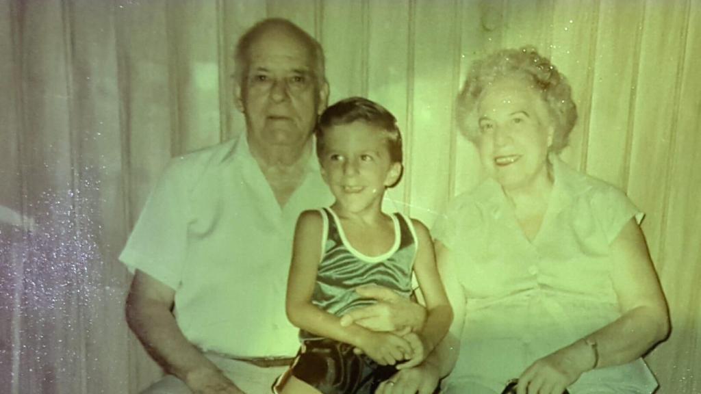 Eduardo, de niño, en una antigua foto con sus abuelos, Eduardo y Ana María, fundadores del negocio.
