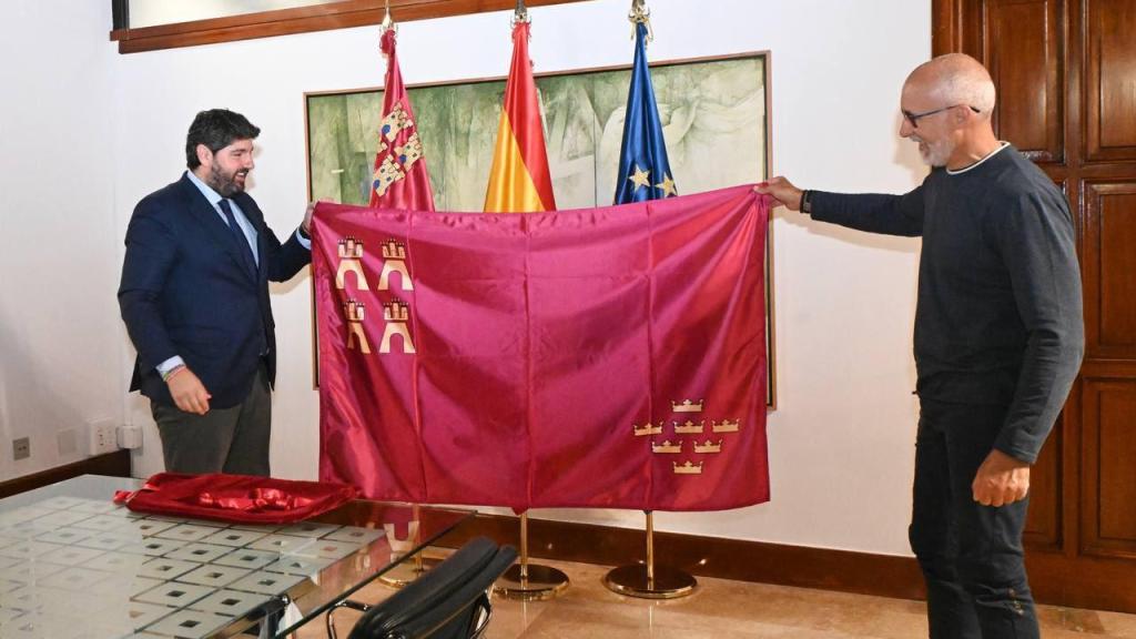 El presidente de la Región de Murcia, Fernando López MIras (i), entrega al explorador Quitín Mira (d) la bandera que colocará al finalizar la expedición 'Mar de Hielo 2025'.