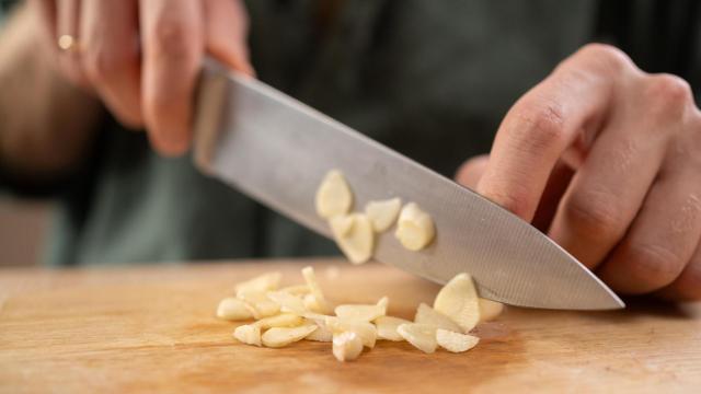 Una persona cortando ajos