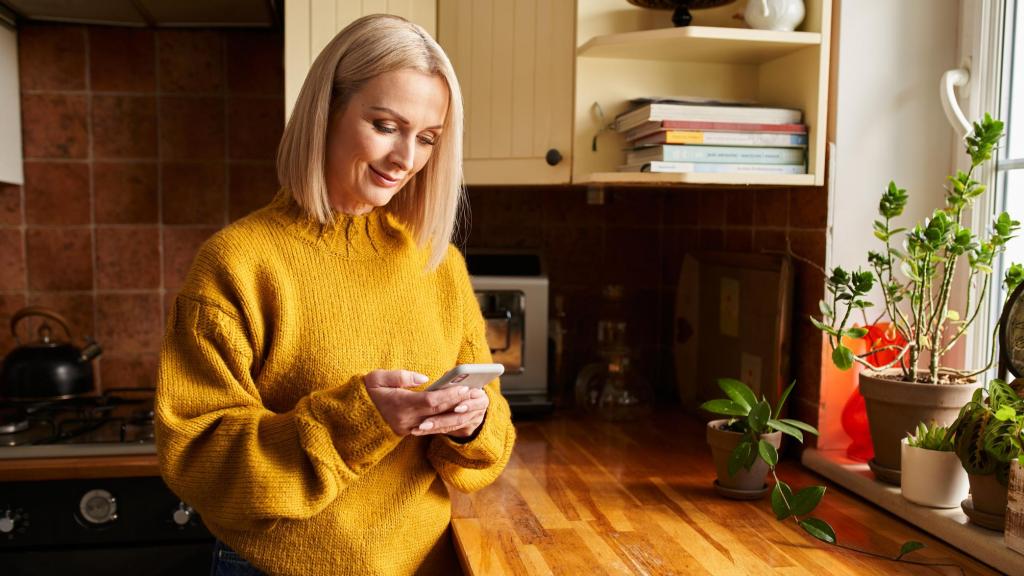 Imagen de archivo de una mujer comprobando su huella de carbono con una app móvil.