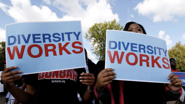 Estudiantes con un cartel que reza la diversidad funciona.