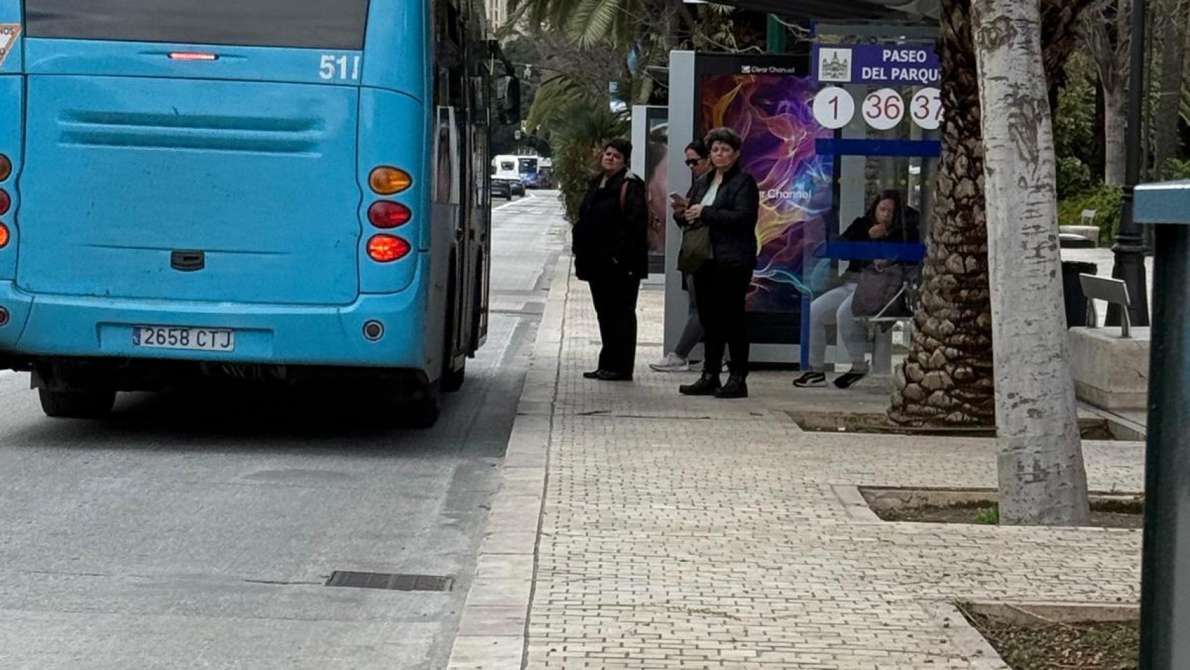 Un grupo de personas espera la llegada de uno de los autobuses de la EMT de Málaga.