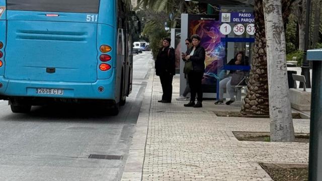 Un grupo de personas espera la llegada de uno de los autobuses de la EMT de Málaga.