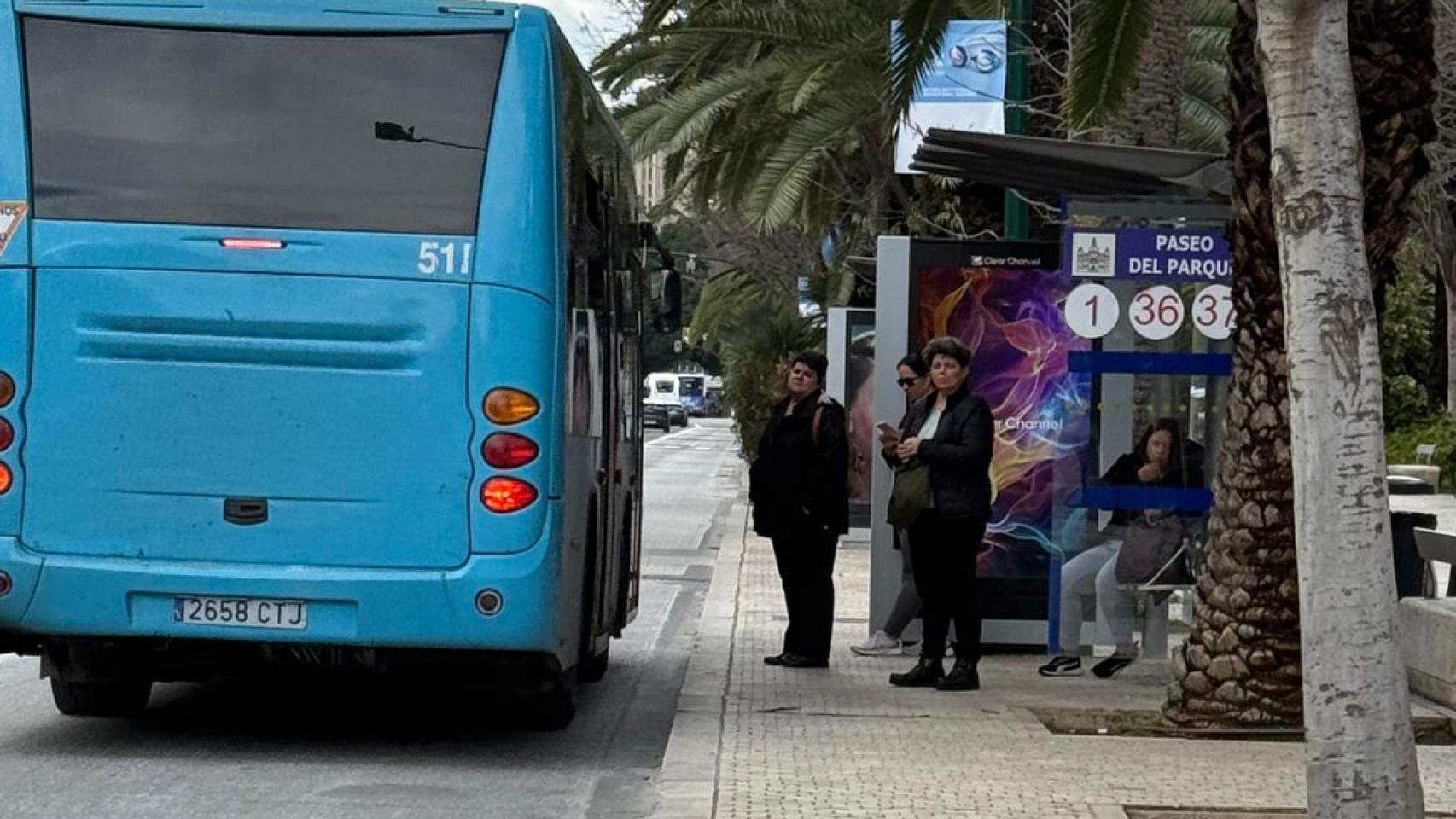 Un grupo de personas espera la llegada de uno de los autobuses de la EMT de Málaga.