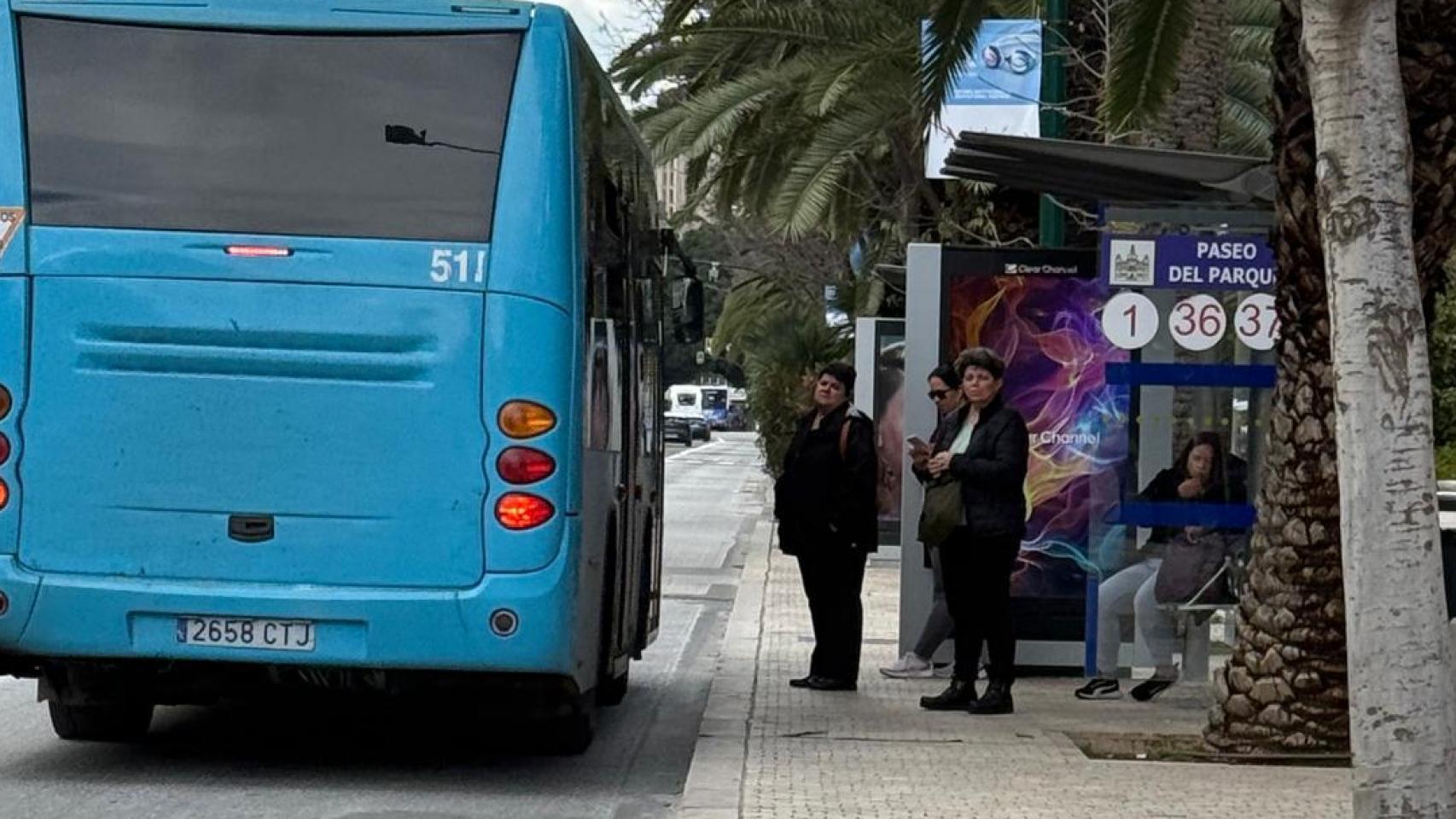 Un grupo de personas espera la llegada de uno de los autobuses de la EMT de Málaga.