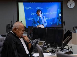 El expresidente filipino Rodrigo Duterte, en una pantalla en la sala del tribunal de la Corte Penal Internacional (CPI) junto a su abogado Salvador Medialdea.