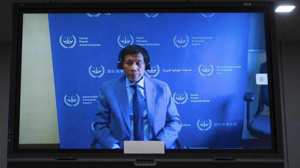 El expresidente filipino Rodrigo Duterte aparece en una pantalla junto a su abogado Salvador Medialdea (I) en la sala de audiencias de la Corte Penal Internacional en La Haya, el 14 de marzo de 2025.