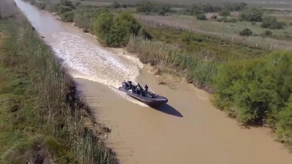 Varios 'narcos' a bordo de una narcolancha por el río Guadalquivir, a su paso por Sevilla.