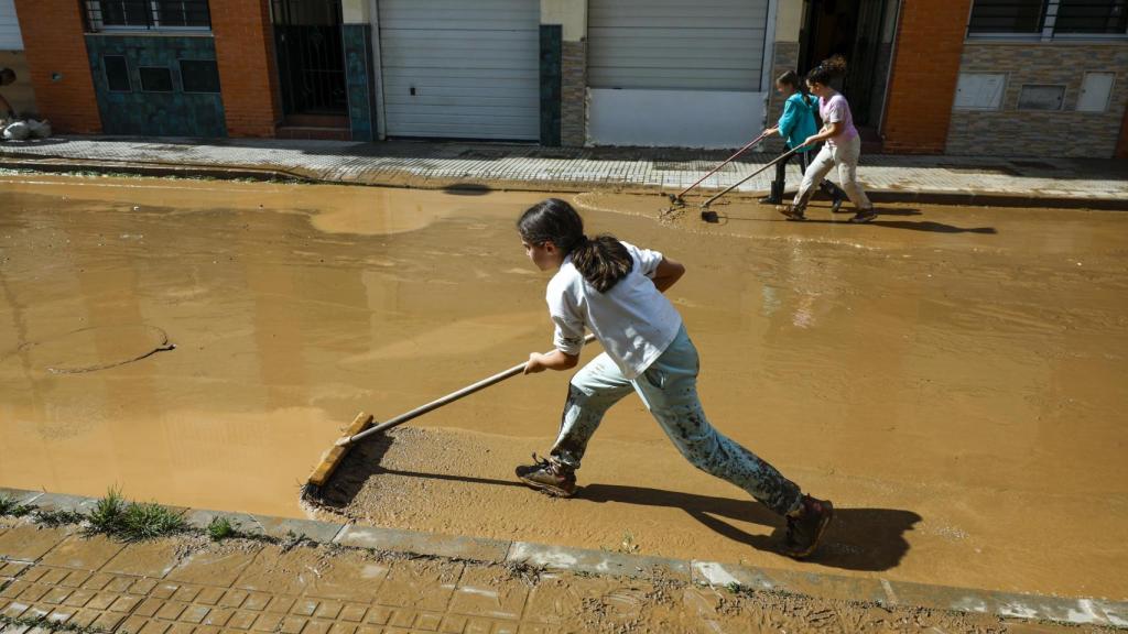 Unos niños limpiando la calle.