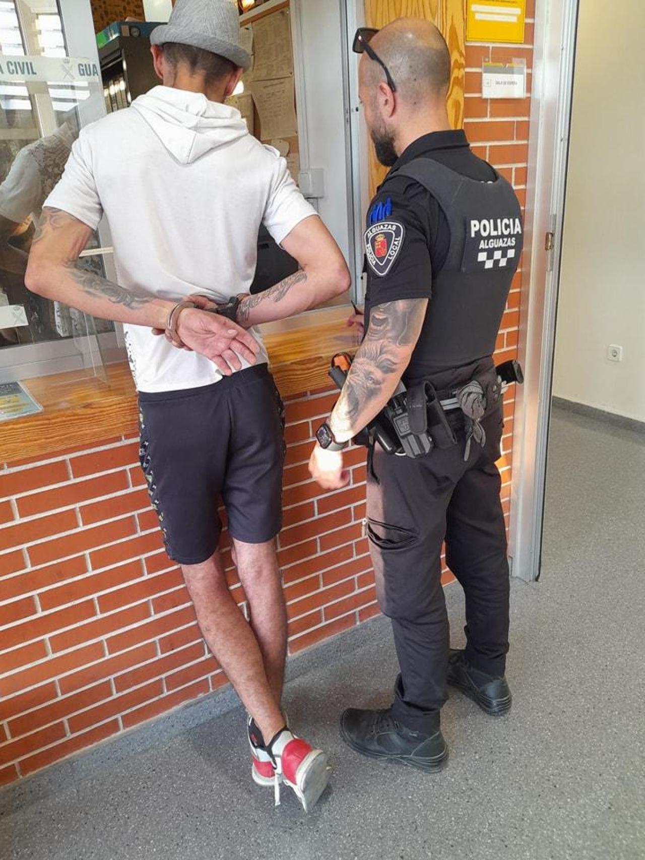 Un policía local de Alguazas custodiando a un individuo que estaba en busca y captura por la presunta comisión de varios delitos.