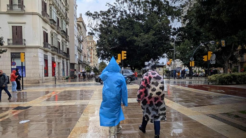 Imagen de archivo de varias personas bajo la lluvia en Málaga.