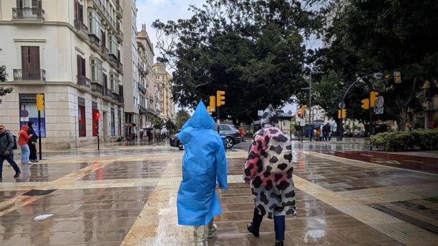 Imagen de archivo de varias personas bajo la lluvia en Málaga.