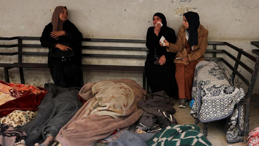 Varias mujeres palestinas rodeadas de cadáveres provocados por el ataque israelí.