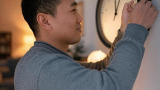 Imagen de archivo de una persona cambiando la hora.