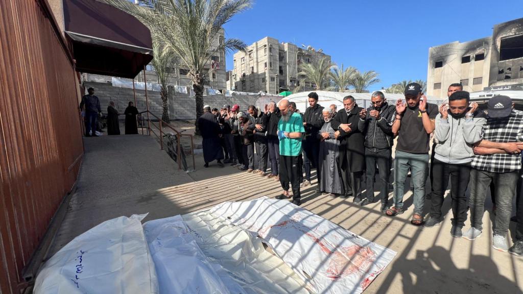 Un grupo de personas vela varios cadáveres provocados por los ataques israelíes en Gaza.