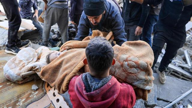 Un hombre carga el cuerpo de un niño palestino que murió esta mañana, según los médicos, en un ataque israelí.