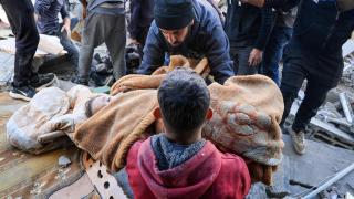 Un hombre carga el cuerpo de un niño palestino que murió esta mañana, según los médicos, en un ataque israelí.
