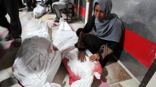 Una mujer llora delante de los cadáveres de varios seres queridos en un hospital de Gaza.