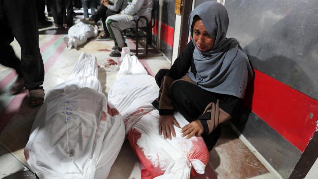 Una mujer llora delante de los cadáveres de varios seres queridos en un hospital de Gaza.