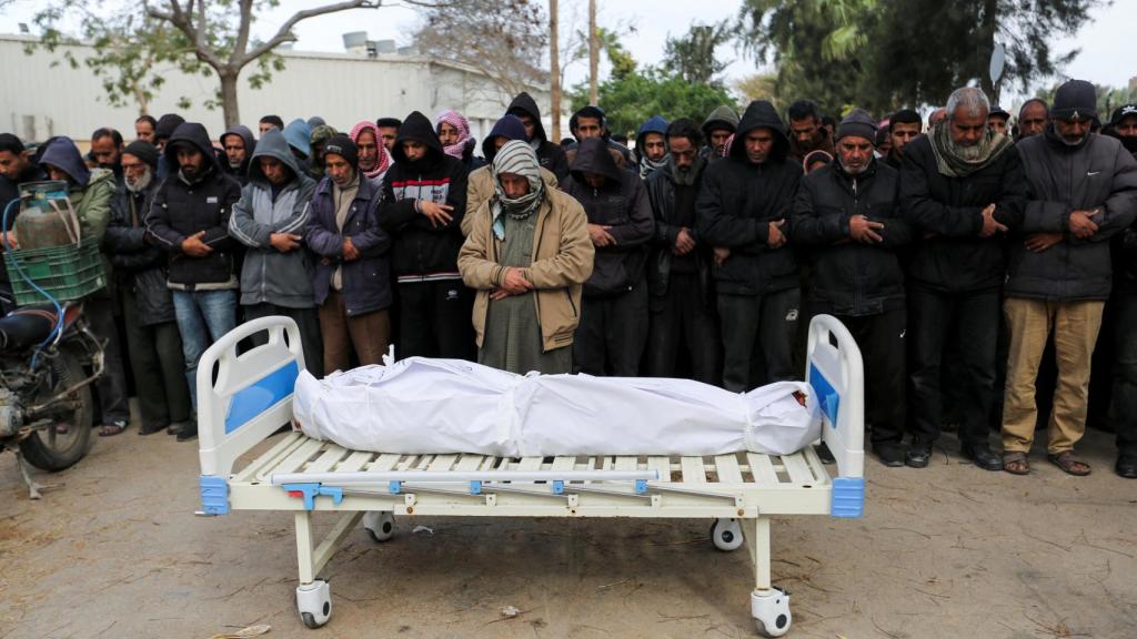 Un grupo de palestinos velan el cadáver de una de las víctimas de Israel.