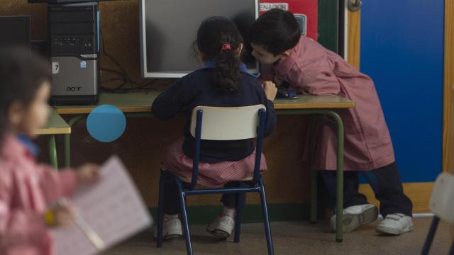Dos niños en un colegio usando un ordenador