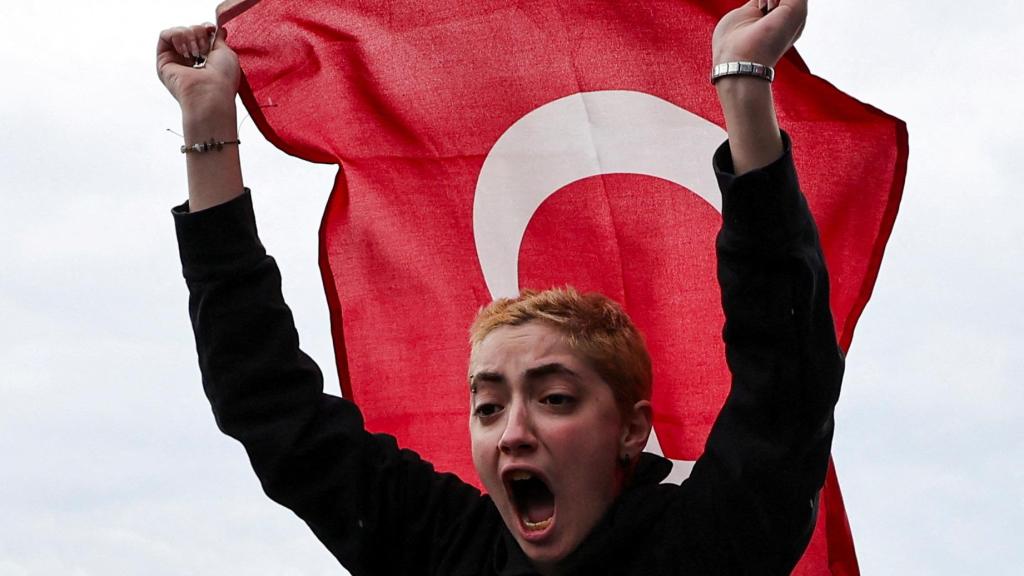 Una joven sostiene la bandera turca n una protesta contra la detención del alcalde de Estambul.