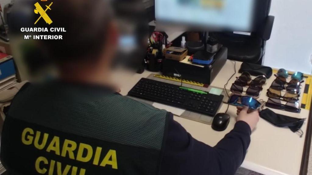 Un agente de la Guardia Civil con objetos intervenidos.