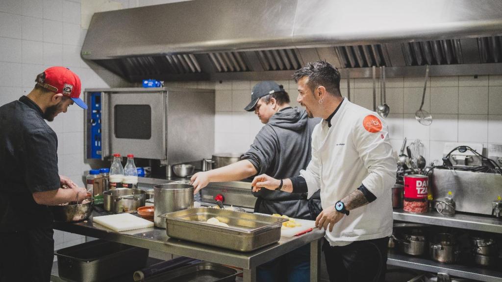 El chef Carlos Maldonado, con dos alumnos de la escuela-restaurante Semillas .