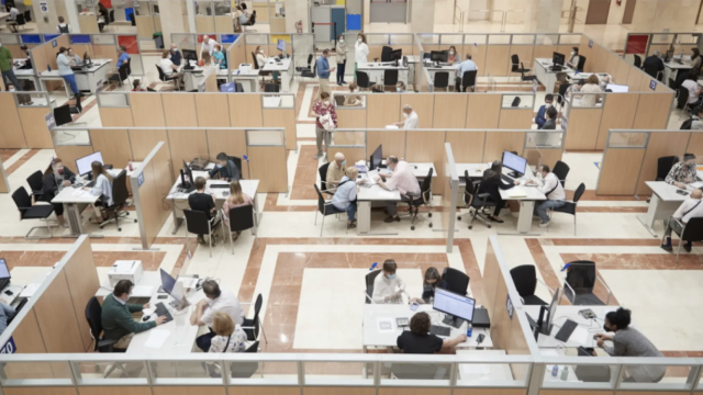 Funcionarios de la administración atienden a varios ciudadanos. EE