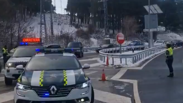 Imagen de dos agentes de la guardia civil informando a los conductores del corte de una carretera