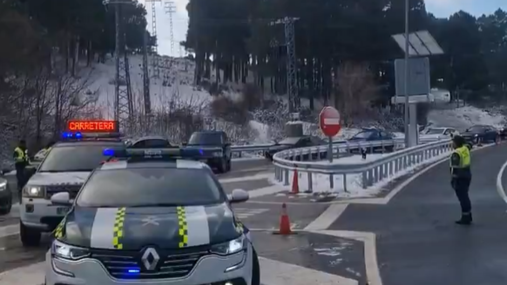 Imagen de dos agentes de la guardia civil informando a los conductores del corte de una carretera