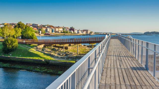 Puente peatonal sobre la desembocadura del río Te con Rianxo (A Coruña) al fondo
