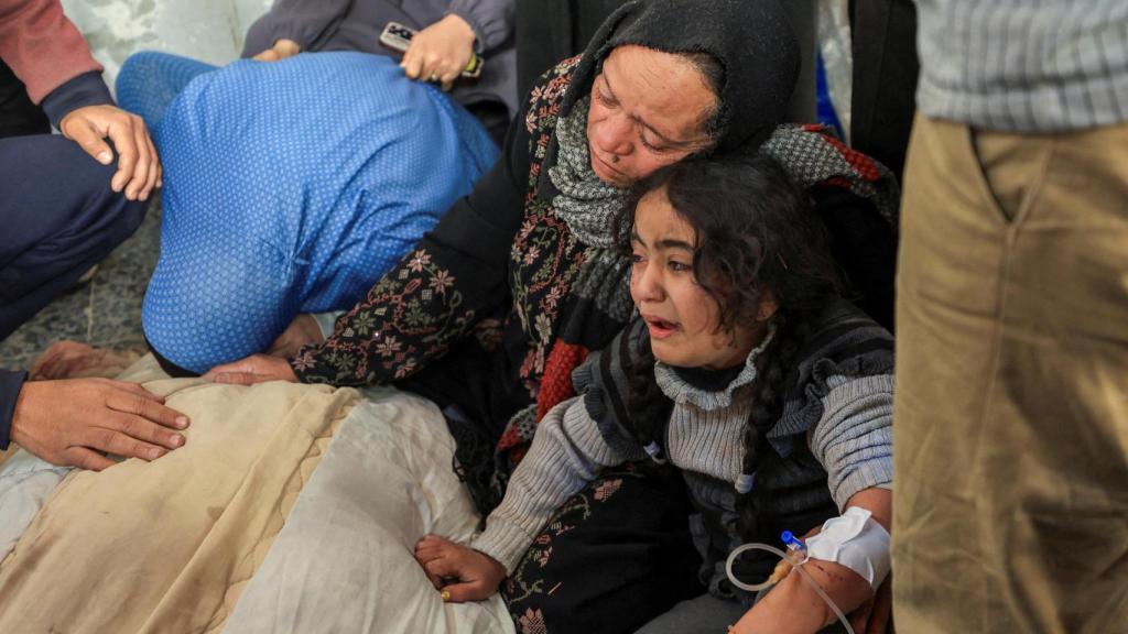 Una madre y su hija lloran la muerte de un familiar por un bombardeo israelí ayer en Gaza.