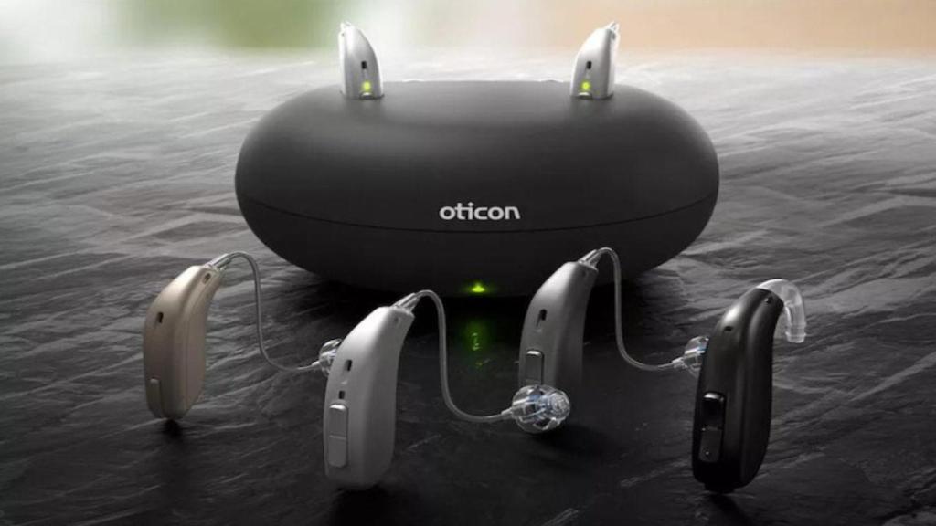 Audífonos junto a la base de recarga