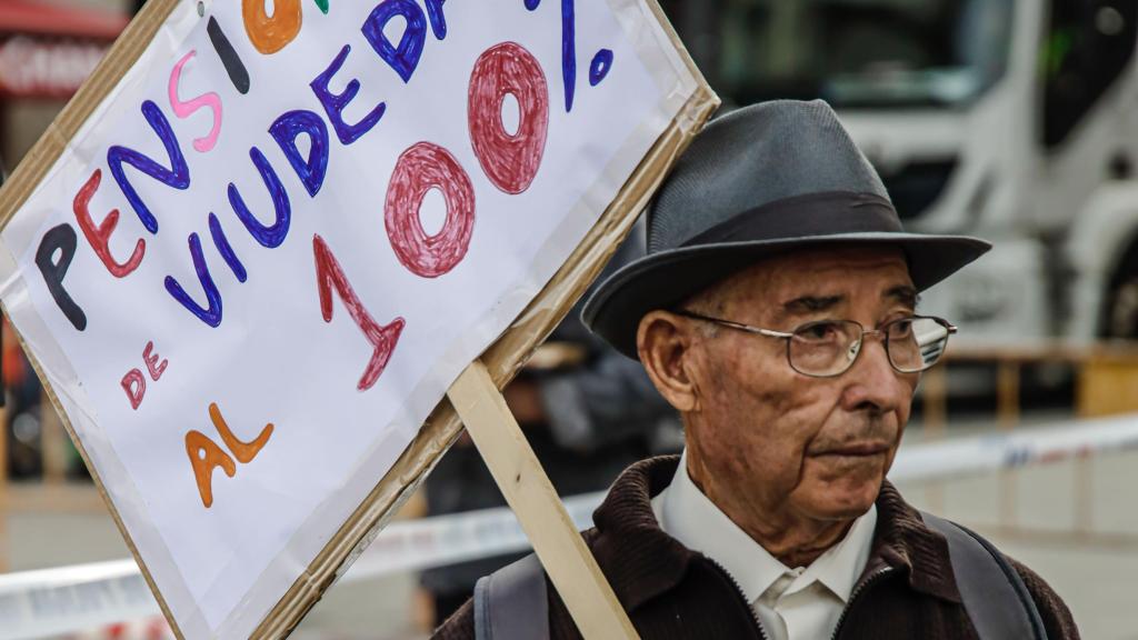 Un hombre con un cartel en el que se lee: 'Pensiones de viudedad al 100%'